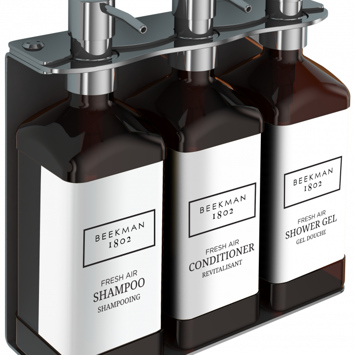 photo of Beekman three-chamber wall-mounted hotel dispenser set, with individual units for Shower Gel, Shampoo, and Conditioner.